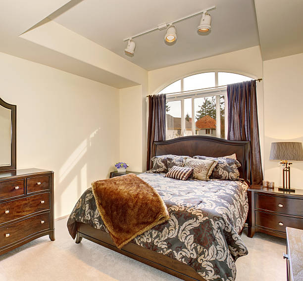 istock Cozy northwest bedroom with brown bedding and white carpet. 481094698