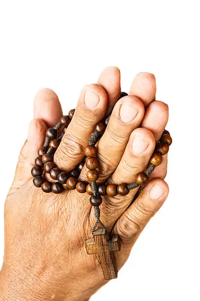 Photo of hands ware binded by wood rosary