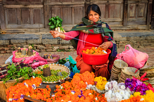 Nepali young woman selling flowers vegetables on Durbar Square in Patan, Nepal.http://bhphoto.pl/IS/nepal_380.jpg