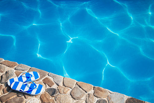 Blue-white  slippers by a swimming pool