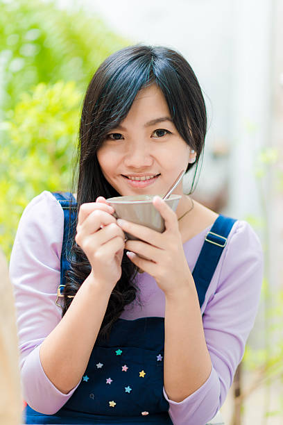 istock Beautiful asian young woman with coffee cup looking to camera 481098256