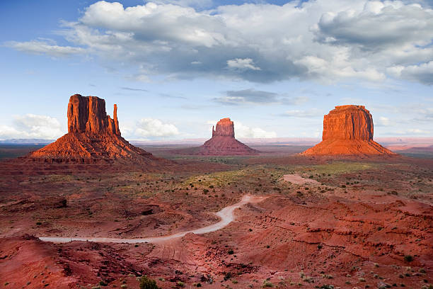 The Mittens and Merrick Butte at Sunset Monument Valley is on the Arizona/Utah border near Oljato, Utah, USA. The valley with its strange sandstone formations is the epitome of the Old West. This iconic view was taken at sunset, capturing the other-worldly glow on the red rock. kayenta photos stock pictures, royalty-free photos & images