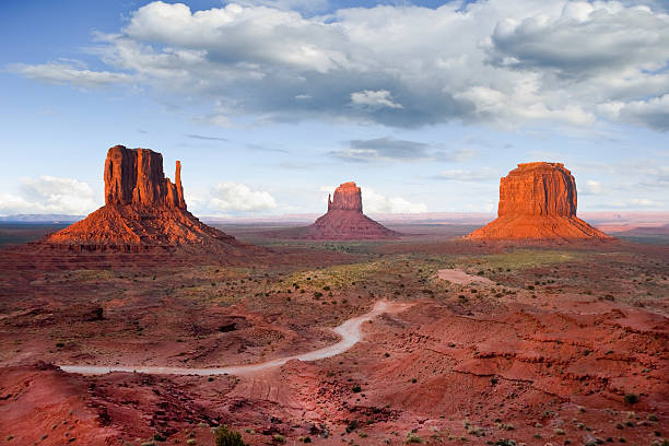 The Mittens and Merrick Butte at Sunset Monument Valley is on the Arizona/Utah border near Oljato, Utah, USA. The valley with its strange sandstone formations is the epitome of the Old West. This iconic view was taken at sunset, capturing the other-worldly glow on the red rock. merrick butte photos stock pictures, royalty-free photos & images