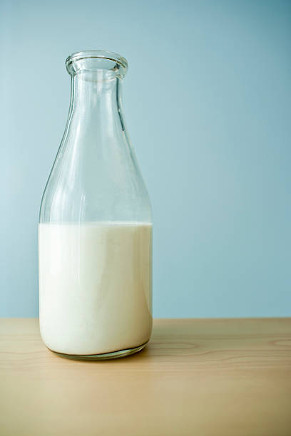 Drink Milk Milk in a old fashioned glass bottle on a table jar of milk stock pictures, royalty-free photos & images