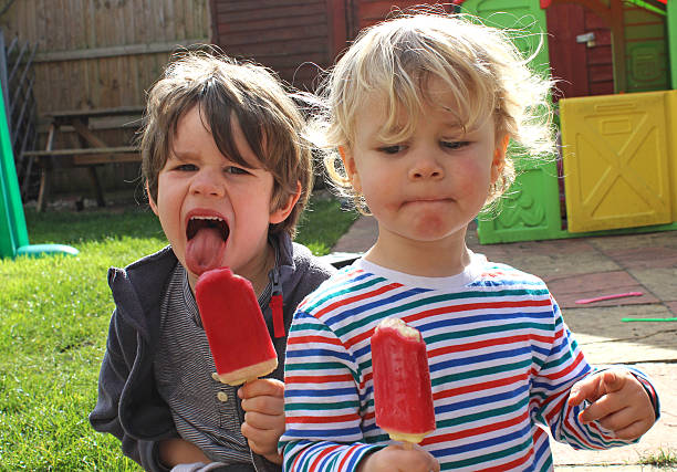 istock brothers eating ice lollies 481103391
