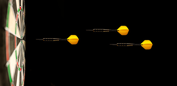 Tres amarillo Airborne de dardos en un objetivo de dardos photo