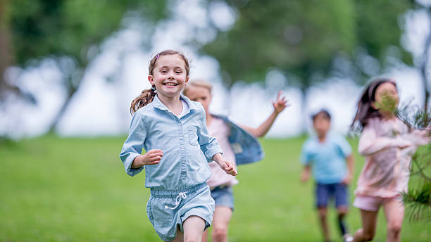 little niños correr al aire libre - child running playing tag fotografías e imágenes de stock