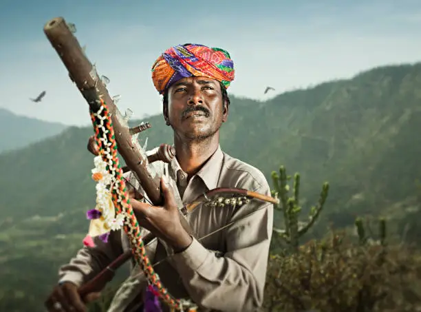 Photo of Folk musician of Rajasthan, India playing traditional musical instrument Ravanahatha.