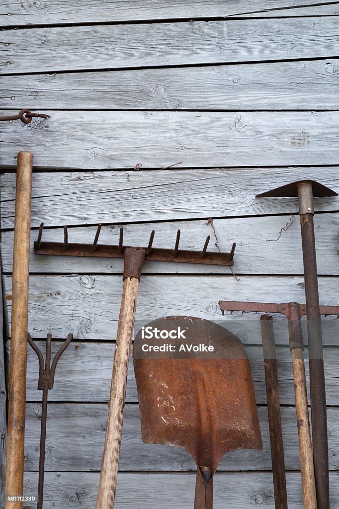 The old rusty tradition tools The old rusty tradition tools, instruments, implements and farm or household equipment on wooden shed wall background Rake Stock Photo