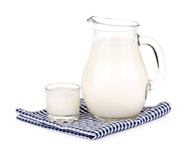 Glass of milk and a milk jug on plaid tablecloth Glass of milk and a milk jug on plaid tablecloth on white background. jar of milk stock pictures, royalty-free photos & images