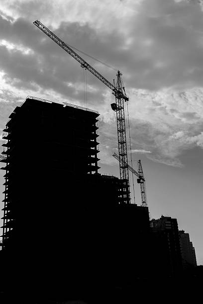 istock silhouette of a tower crane is involved in the construction 481116470