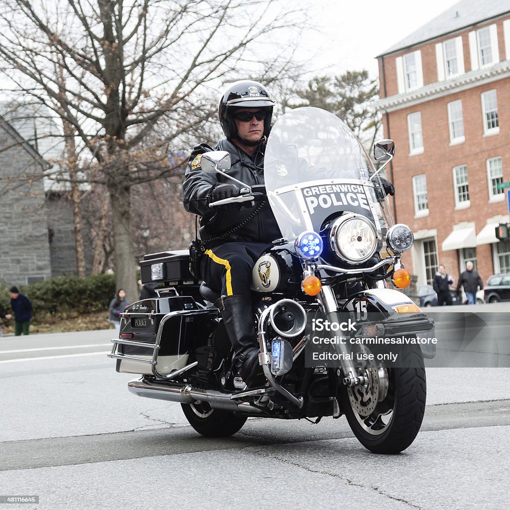 policeman Greenwich, CT, USA - March 23, 2014: Close-up of a policeman on a motorcycle and is participating in the town annual "St. Patrick's Day Parade". The parade consists of over forty groups including clowns, dancers, bagpipe bands, local school marching bands, fire department and police department along with local politicians Close-up Stock Photo