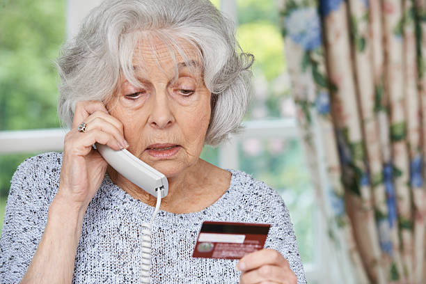 Senior Woman Giving Credit Card Details On The Phone stock photo