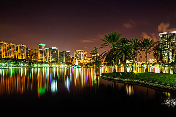 Orlando downtown skyline over Lake Eola at night Orlando downtown skyline over Lake Eola at night with urban skyscrapers.  RM lake eola stock pictures, royalty-free photos & images