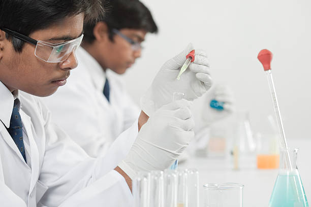 Adolescentes no ensino médio de ciências de alunos de aprendizagem prática química no laboratório. - foto de acervo