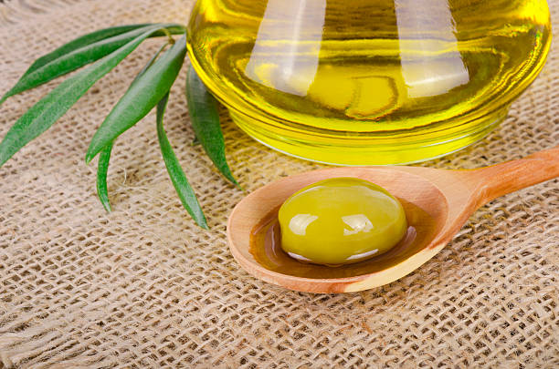 Olive Oi Olive Oil on a wooden table olive oil pouring antioxidant liquid stock pictures, royalty-free photos & images