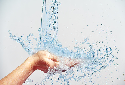 woman hand with water splashes and drops, concept of beauty and skin care