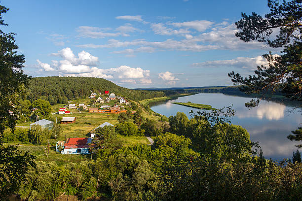 istock Village on river bank, reflections in water and solar day 481125360
