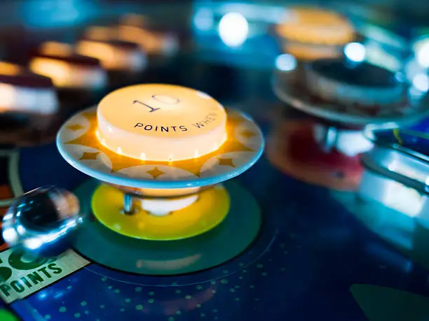 Photo of Antique Pinball Machine with Ball in motion