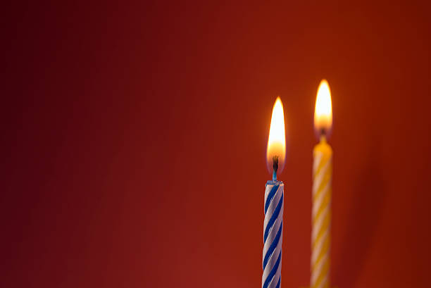 istock Burning birthday candles on red background with copyspace 481130431