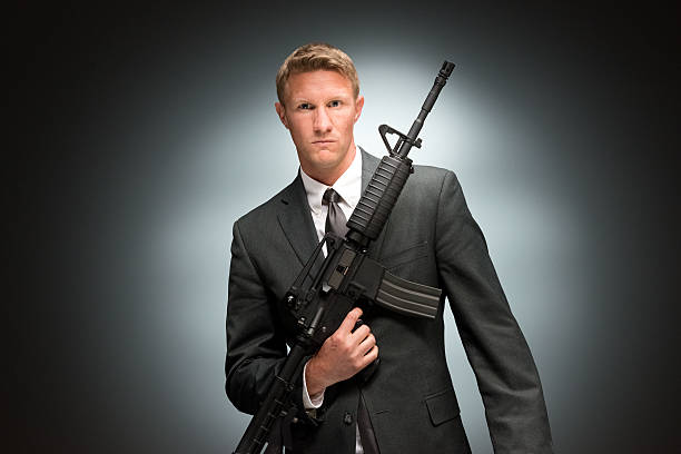 istock Spy holding rifle and looking at camera 481131180