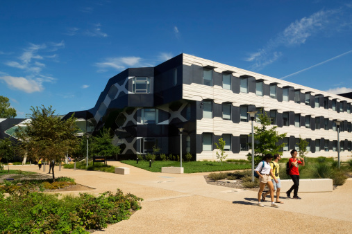 Canberra, Australia - March 14, 2014: A multicultural group of students walk past the Linnaeus Building at the Australian National University. Located within the College of Science Precinct, the building houses the Research School of Biology, various departments and laboratories.
