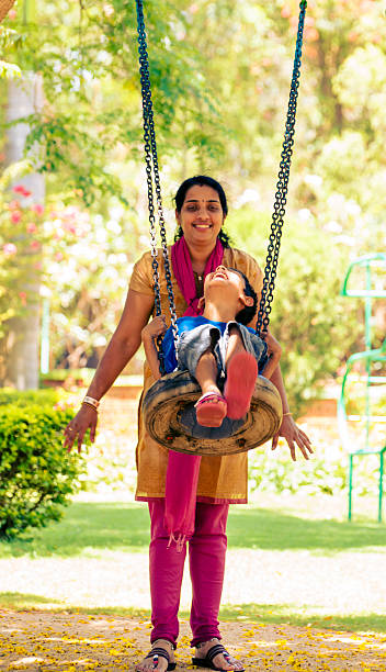 istock Mother pushing her son in a tree swing 481137897