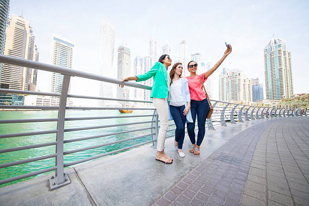 istock Smiling women taking selfie against cityscape 481149118