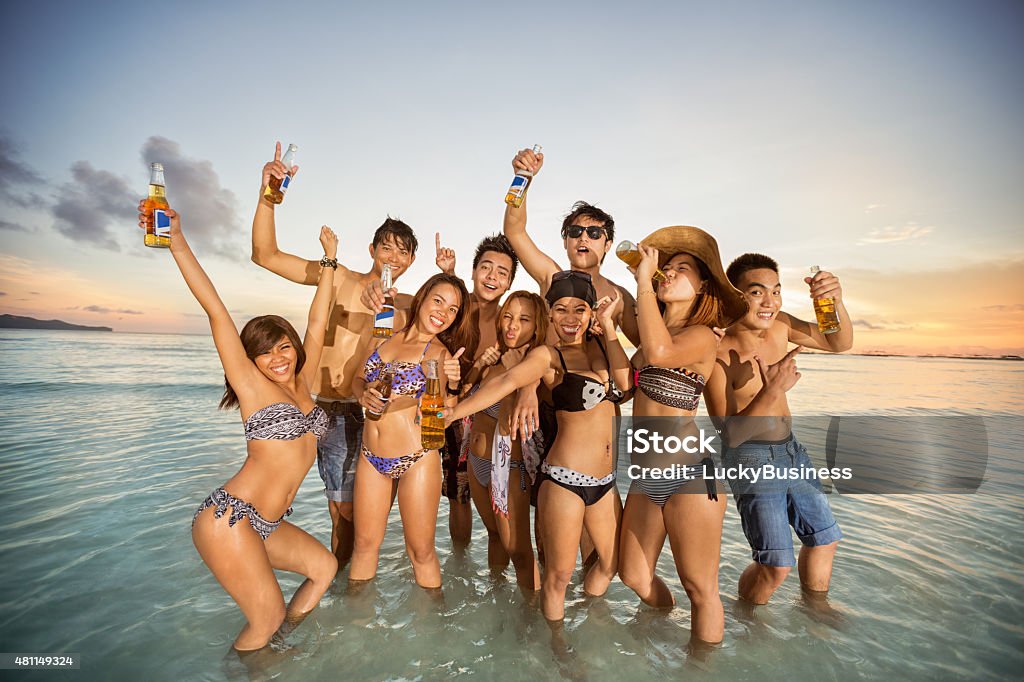 Group of friends having fun on summer beach Group of young friends having fun on summer beach, party on sea 2015 Stock Photo