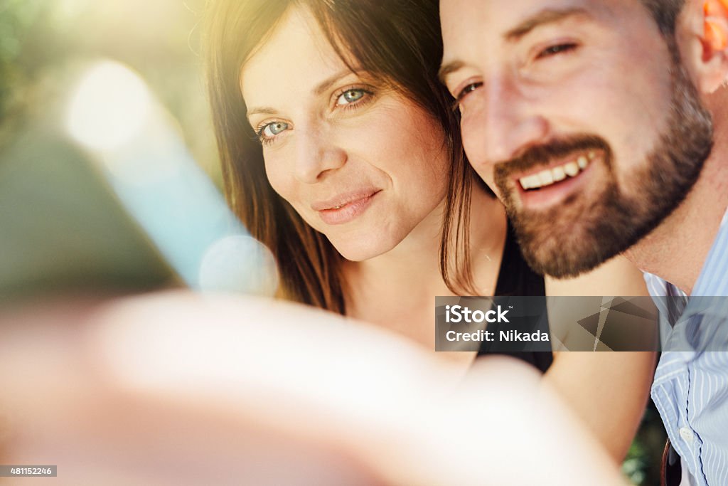 Young happy couple taking a selfie with cell phone outdoors 2015 Stock Photo