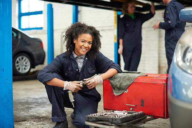 Portrait of a beautiful young mechanic girl working in auto repair shop.