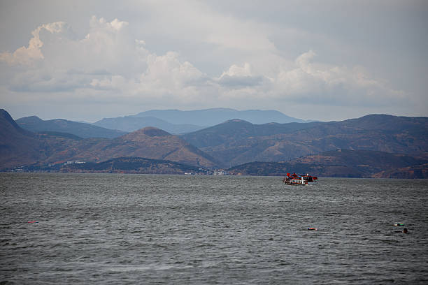 Erhai Lake is the largest highland lake next to Dianchi and one of the seven biggest fresh water lakes in China. It means, 'sea shaped like an ear', in Chinese. Implying that the lake is ear shaped and as large as a sea, hence it was so named. The lake covers an area of 250 square kilometers and is located about two kilometers east of Dali. It is like a crescent lying between Cangshan and Dali city as seen from Cangshan Mount. In a sunny day, the crystal waters of Erhai Lake and the snow mantled Cangshan Mount radiate with each other. Thus the scene was commonly described as 'Silver Cangshan and Jade Erhai'.