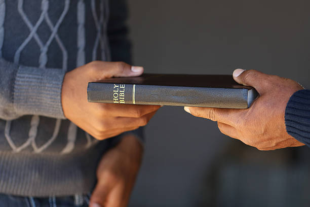 Sharing the Gospels Older man sharing the gospel with teenagers and young adults. black gospel church stock pictures, royalty-free photos & images