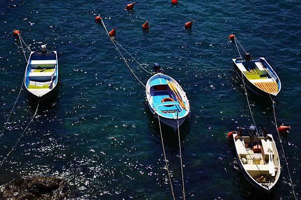 Four colorful rowboats along the coast of Italy in the the delightful villages of Cinque Terre