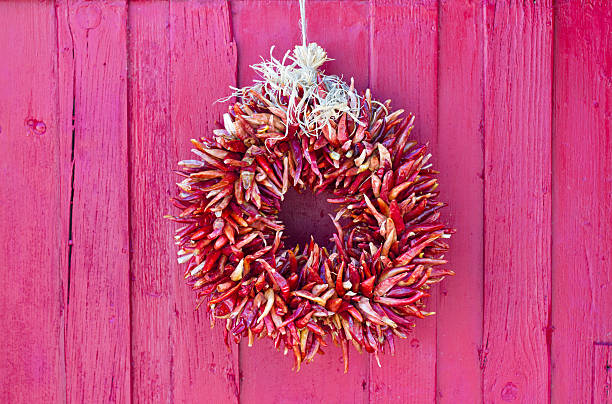 santa-fe-stil: red chili kranz auf red door - wreath chili pepper pepper ristra stock-fotos und bilder