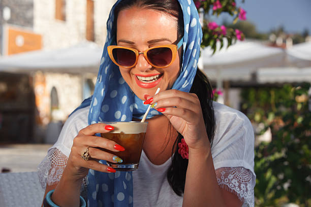 Woman enjoying sunset with a cup of coffee outdoors in a street cafe