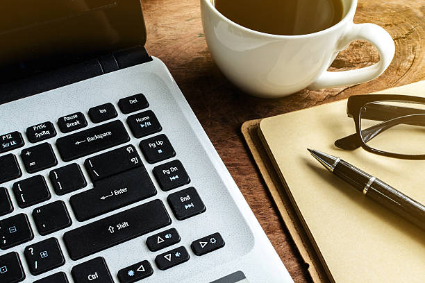 istock Laptop and cup of coffee on old wooden table 481166906