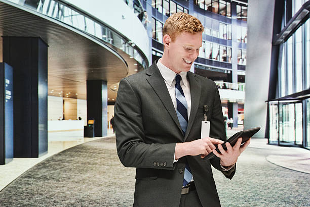 sorridente uomo d'affari utilizzando il tablet - office indoors contemporary office building foto e immagini stock