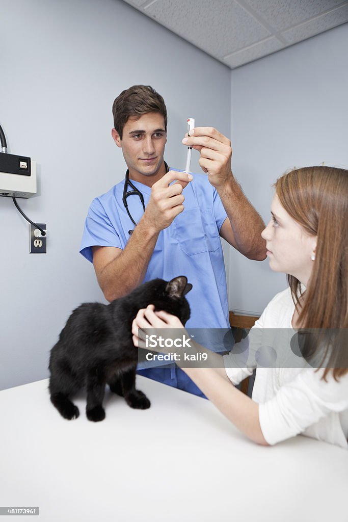 Girl taking pet cat to vet Girl (10 years) taking pet cat to veterinarian for shot.   Focus on man. Veterinarian Stock Photo