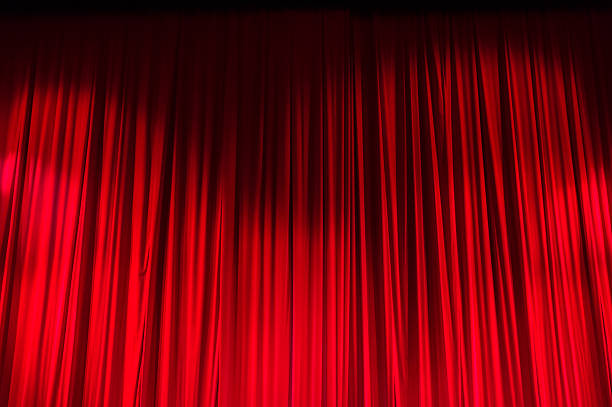 istock Red closed curtain with light spots in a theater 481175034