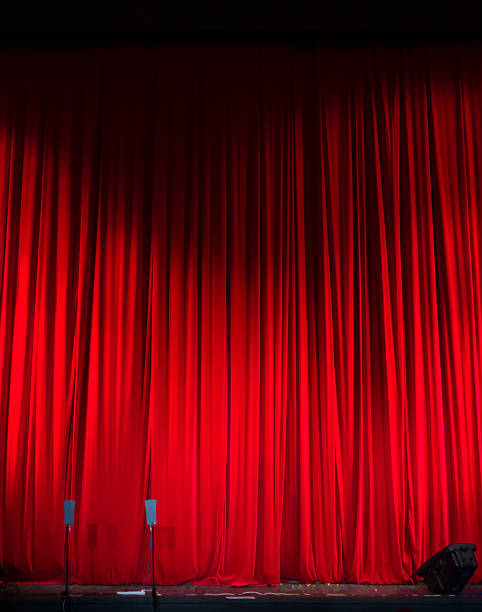 istock Red closed curtain with light spots in a theater 481175316