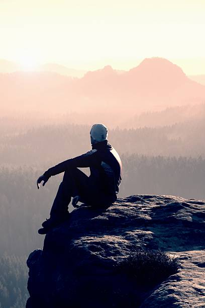 istock Hiker sits on a rocky peak and enjoy the scenery 481175826