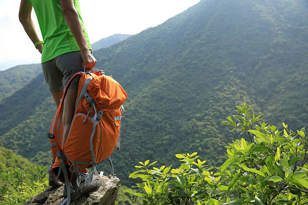 woman backpacker enjoy the view at mountain peak cliff