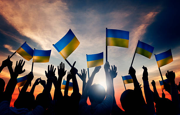 istock Group of People Waving Ukranian Flags in Back Lit 481177092