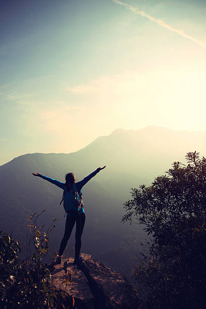 istock cheering woman hiker open arms at mountain peak 481178806