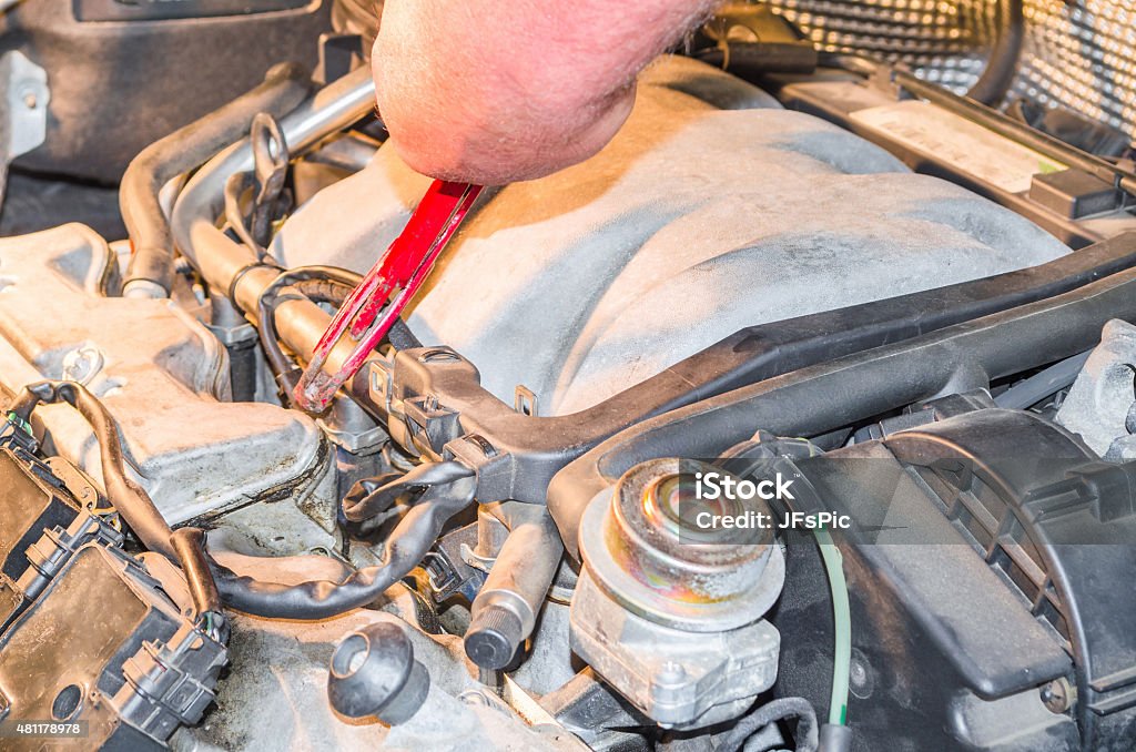 Car engine Service Hand of an auto mechanic in the engine compartment in the car-repair workshop. 2015 Stock Photo
