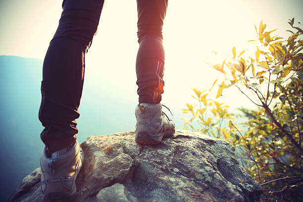 istock woman hiker legs stand on mountain peak rock 481186872