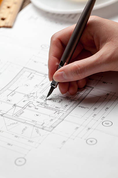 istock woman holding a pen over a house constructing plan 481187064