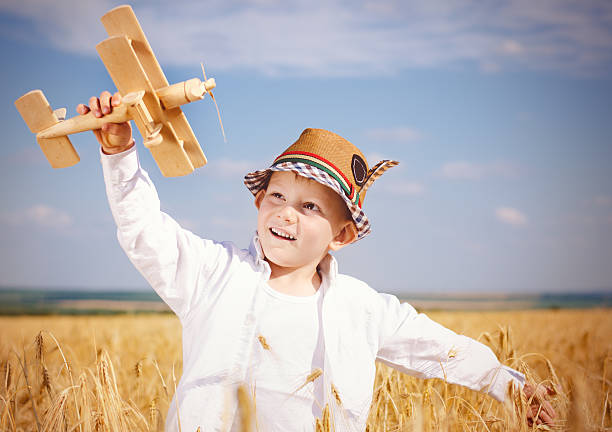 istock Trendy young boy playing in a field with a plane 481187370