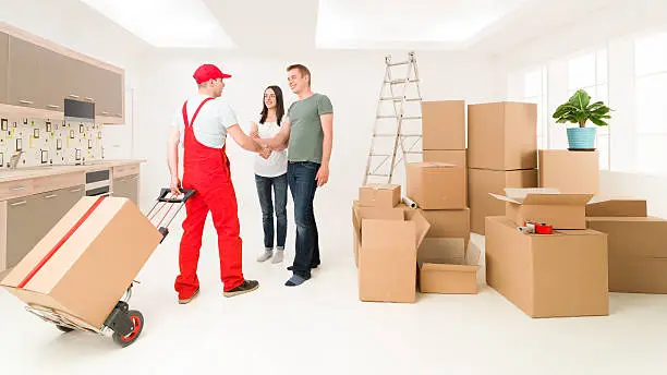 couple moving in new home and receiving package from delivery man